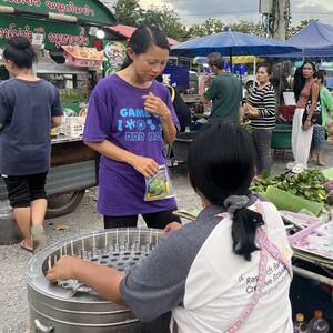 Sun sharing a Bible story with a local vendor