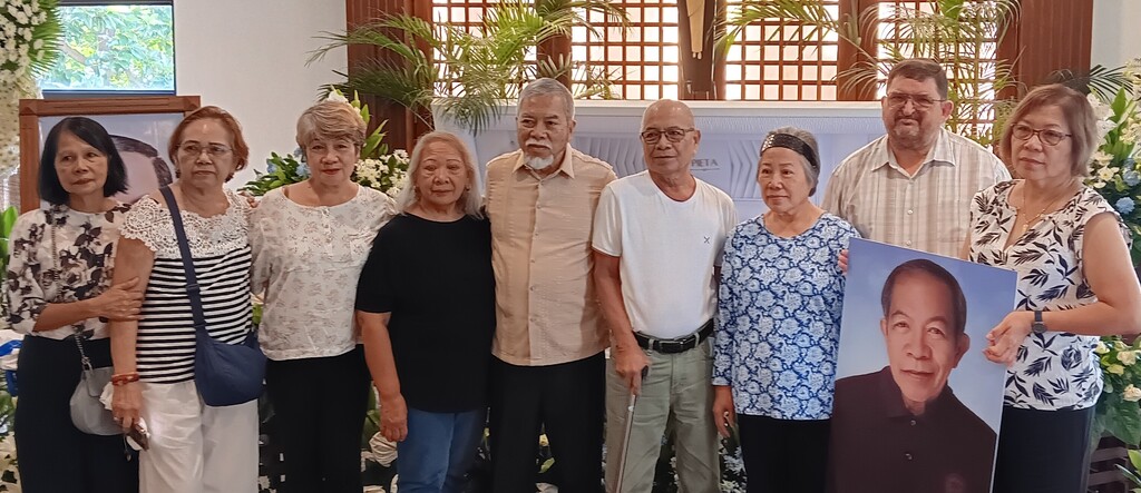 Amor’s four living siblings and their spouses in front of her brother's casket on September 23 in the Philippines